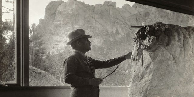 Gutzon Borglum (1867-1941), American sculptor, at work in his studio on the model for Mt. Rushmore. Photograph circa 1930s.