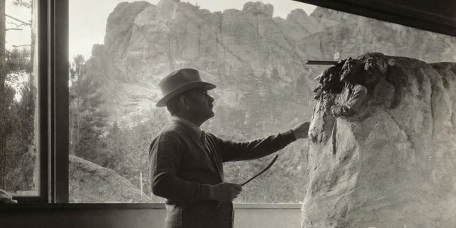 Gutzon Borglum (1867-1941), American sculptor, at work in his studio on the model for Mt. Rushmore. Photograph circa 1930s. 