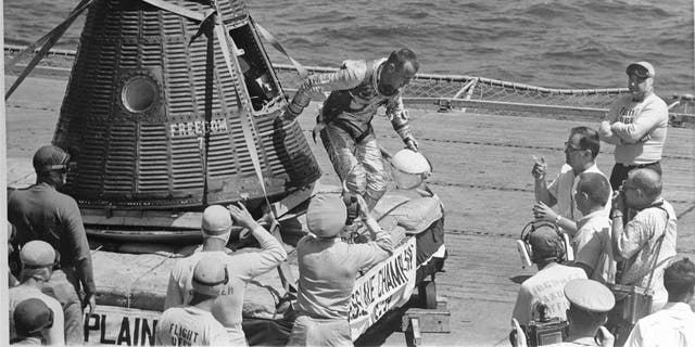 American sailor and astronaut Alan B. Shepard (1923-1998) as he emerges from the Freedom 7 space capsule onto the flight deck of the recovery carrier USS Lake Champlain (CV-39) after his historic Mercury 3 flight, Atlantic Missile Range, May 5, 1961. Shepard became the first American in space and also became the first human to return to Earth in his spacecraft, as Soviet cosmonauts had parachuted during re-entry. 