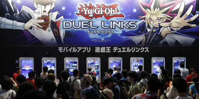 Visitors play Yu-Gi-Oh! Duel Links video game in the Konami Holdings Corp. booth at Tokyo Game Show on Sept. 17, 2016, in Chiba, Japan.