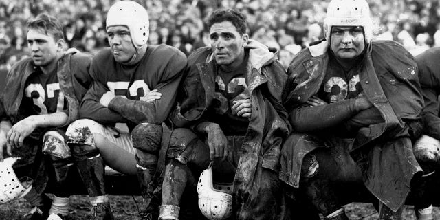 Halfback Charley Trippi of the Chicago Cardinals, along with Vic Schwall (37), Bill Campbell(53) and Vince Banonis (32) on the bench during a 45-to-21 loss to the Washington Redskins on November 23, 1947, at Griffith Stadium in Washington, DC. 