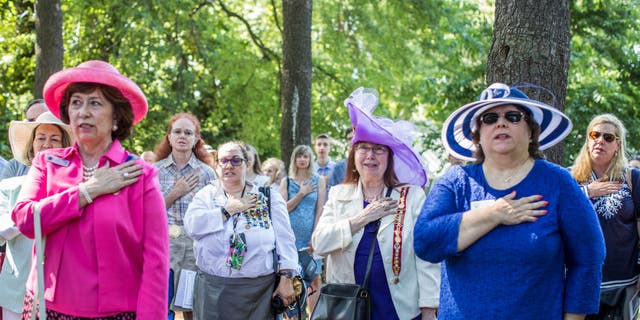 Women with the Daughters of the American Revolution say a prayer during the dedication ceremony of the Wren-Darne Cemetery on July 14, 2018, in Falls Church, Virginia. 