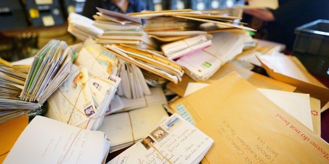 In this image released on Sept. 30, letters of condolence sent by members of the public to King Charles III, the queen consort and the royal family are sorted by the Correspondence Team at Buckingham Palace. Since the death of Queen Elizabeth II, over 50,000 letters and messages of condolence have been sent to Buckingham Palace, including 6,500 in just one day after the Queen's state funeral. 