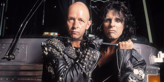 Rob Halford, left, and Alice Cooper pose in front of a tour bus, circa 1990s.