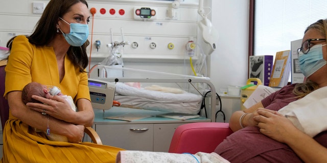 Britain's Catherine, Princess of Wales, speaks to new mother Sylvia Novak while holding Sylvia's newborn daughter Bianca during a visit to the Royal Surrey County Hospital's maternity unit in Guildford, southwest of London Oct. 5, 2022. 