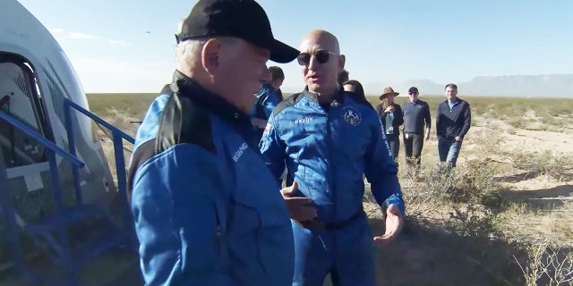 Jeff Bezos greets William Shatner in matching Blue Origin jumpsuits after space mission