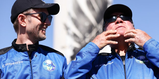 ‘Star Trek’ actor William Shatner (R) gestures as Planet Labs co-founder Chris Boshuizen looks on during a media availability on the landing pad of Blue Origin’s New Shepard after they flew into space on October 13, 2021, near Van Horn, Texas. Shatner became the oldest person to fly into space on the 10-minute flight. They flew aboard mission NS-18, the second human spaceflight for the company which is owned by Amazon founder Jeff Bezos. 