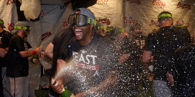 Atlanta Braves left fielder Guillermo Heredia, center, celebrates in the clubhouse after Atlanta clinched its fifth consecutive N.L. East title by defeating the Miami Marlins on Oct. 4, 2022, in Miami.
