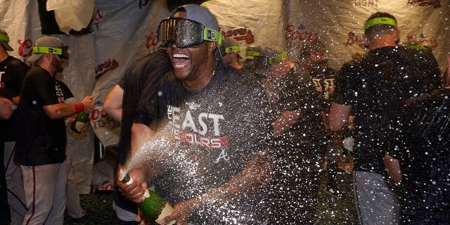 Atlanta Braves left fielder Guillermo Heredia, center, celebrates in the clubhouse after Atlanta clinched its fifth consecutive N.L. East title by defeating the Miami Marlins on Oct. 4, 2022, in Miami.