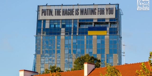 A general view of the Vilnius city municipality building in Lithuania sports a banner proclaiming, "Putin, The Hague Is Waiting For You", Tuesday, October 4, 2022.