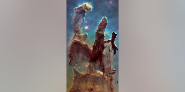 NASA's Hubble Space Telescope has revisited the famous Pillars of Creation, revealing a sharper and wider view of the structures in this visible-light image. Astronomers combined several Hubble exposures to assemble the wider view. The towering pillars are about 5 light-years tall. The dark, finger-like feature at bottom right may be a smaller version of the giant pillars. The new image was taken with Hubble's versatile and sharp-eyed Wide Field Camera 3. The pillars are bathed in the blistering ultraviolet light from a grouping of young, massive stars located off the top of the image. Streamers of gas can be seen bleeding off the pillars as the intense radiation heats and evaporates it into space. Denser regions of the pillars are shadowing material beneath them from the powerful radiation. Stars are being born deep inside the pillars, which are made of cold hydrogen gas laced with dust. The pillars are part of a small region of the Eagle Nebula, a vast star-forming region 6,500 light-years from Earth. The colors in the image highlight emission from several chemical elements. Oxygen emission is blue, sulfur is orange, and hydrogen and nitrogen are green.