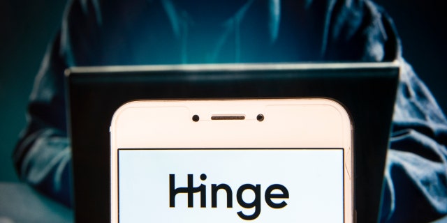 HONG KONG, CHINA - 2018/12/02: In this photo illustration, the online dating app Hinge logo is seen displayed on an Android mobile device with a figure of hacker in the background. 