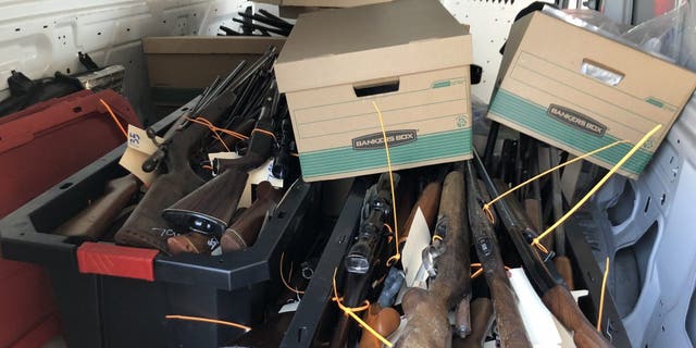 Dozens of guns sit in boxes following a buyback event in Houston, Texas on Oct. 8, 2022.