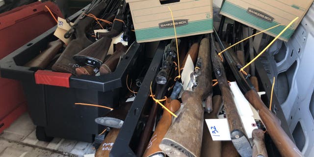 Dozens of guns sit in boxes following a buyback event in Houston, Texas on Oct. 8, 2022.