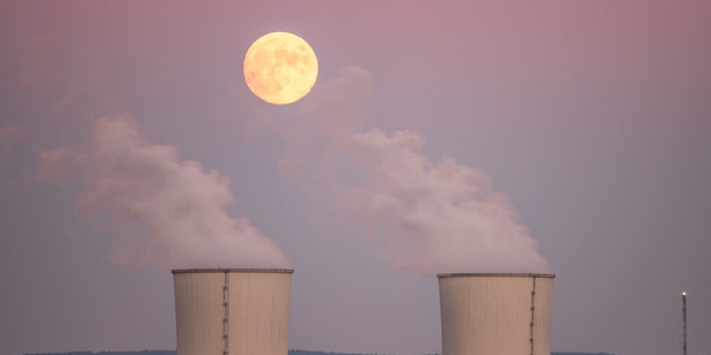 TRILLO, GUADALAJARA, SPAIN - 2021/10/19: An almost full moon of October, known as Hunter's Moon, rises over the cooling towers of the Trillo Nuclear Power Plant. 