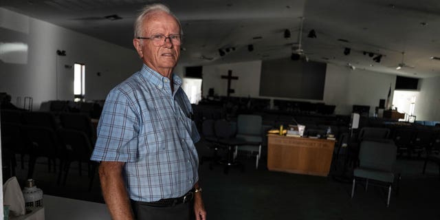 Pastor Robert Kasten, pastor of Southwest Baptist Church in Fort Myers, Florida, stands at the sanctuary where parishioners evacuated when Hurricane Ian hit southwest Florida on Sunday, October 2, 2022. .  (AP Photo/Robert Bumsted)