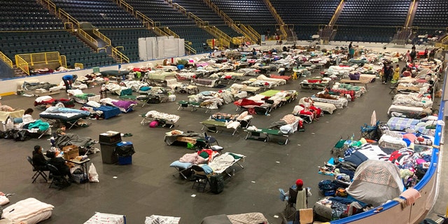 Cots cover the floor of Hertz Arena, an ice hockey venue that has been transformed into a massive relief shelter, in Estero, Fla., on Saturday, Oct. 8, 2022.