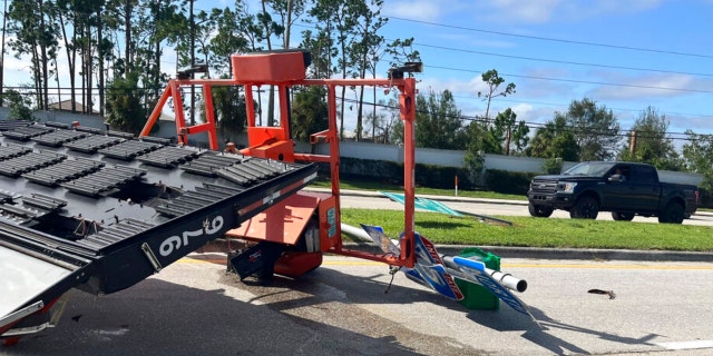 An electronic highway sign lies toppled on a highway information sign pointing the way to Interstate 75, in Fort Myers, Fla., Thursday, Sept. 29, 2022, following Hurricane Ian.