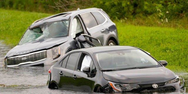 Vehicles sit in floodwaters on the side of Interstate 75 in North Port, Fla., following Hurricane Ian, Thursday, Sept. 29, 2022. 