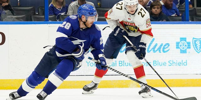 Florida Panthers center Eetu Luostarinen (27) works around Tampa Bay Lightning defenseman Ian Cole (28) during the third period of an NHL preseason game Saturday, Oct. 8, 2022, in Tampa, Fla.