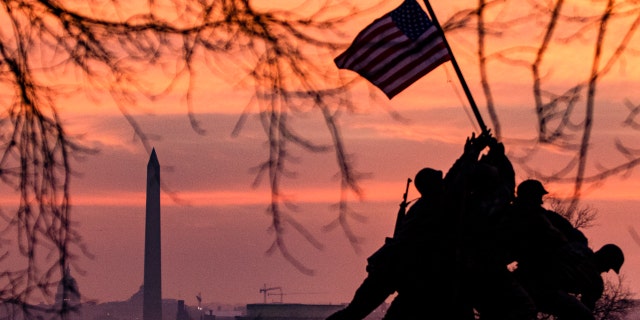 The American flag flies above the Iwo Jima Memorial with the Washington Monument in the distance on Jan. 15, 2021, in Arlington, Virginia.