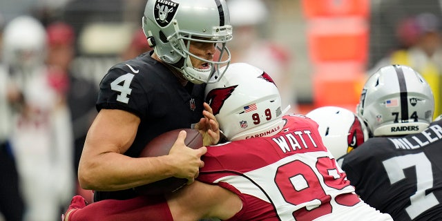 Las Vegas Raiders quarterback Derek Carr (4) is sacked by Arizona Cardinals defensive end J.J. Watt (99) during the first half of an NFL football game Sunday, Sept. 18, 2022, in Las Vegas.