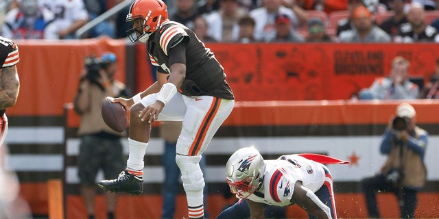 Cleveland Browns quarterback Jacoby Brissett (7) evades New England Patriots linebacker Mack Wilson Sr., right, as he scrambles during the second half of an NFL football game, Sunday, Oct. 16, 2022, in Cleveland.