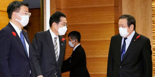 Japan's Prime Minister Fumio Kishida, second left, talks to Defense Minister Yasukazu Hamada, right, as they gather for a cabinet meeting at Kishida's office in Tokyo Friday, Oct. 14, 2022.
