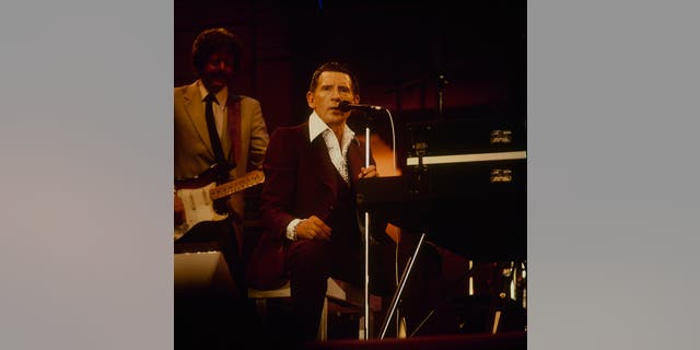 Jerry Lee Lewis performs on stage at the Country Music Festival at Wembley Arena in London in April 1987.