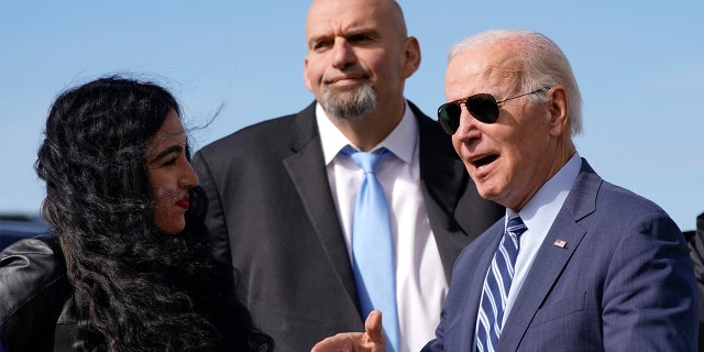 President Biden talks with John Fetterman and his wife Gisele Barreto Fetterman, at Pittsburgh International Airport in Coraopolis, Pennsylvania, on Oct. 20, 2022.