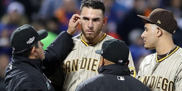 Umpire Alfonso Marquez, #72, and crew check for illegal substances on San Diego Padres starting pitcher Joe Musgrove, #44, during the sixth inning in game three of the Wild Card series for the 2022 MLB Playoffs at Citi Field in New York Oct. 9, 2022.