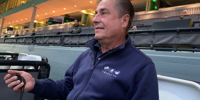 Trainer John Sadler watches his horse.