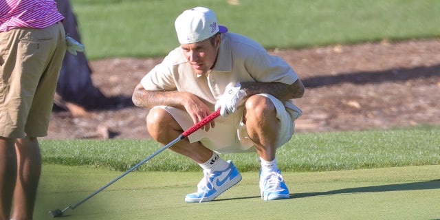 Justin Bieber eyes his shot on Saturday at the Hillcrest Country Club in Los Angeles.