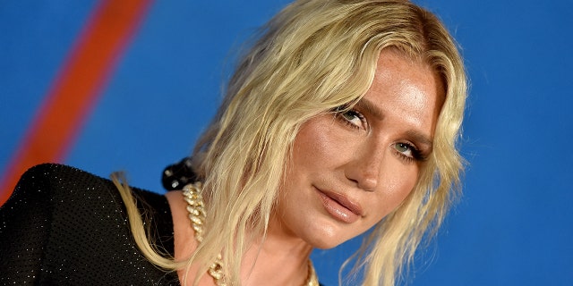 Kesha walks red carpet wearing black dress