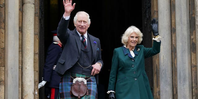 King Charles III and Camilla, Queen Consort, wave as they leave Dunfermline Abbey after a visit to mark its 950th anniversary on Oct. 3, in Scotland.