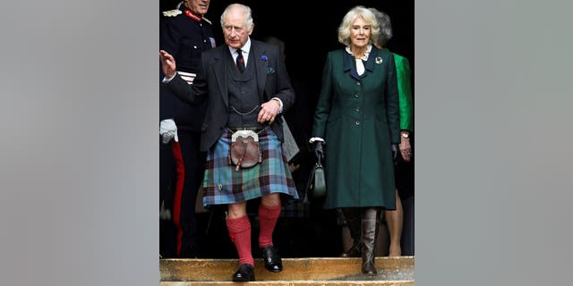 Britain's King Charles III, wearing a kilt, and Britain's Camilla, queen consort, walk to meet members of the public after leaving from City Chambers to Dunfermline Abbey in Dunfermline.