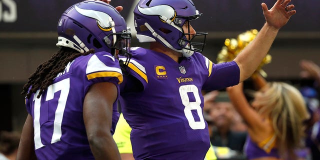 Minnesota Vikings quarterback Kirk Cousins ​​(8) viert feest met teamgenoot KJ Osborn na het scoren op een 17-yard touchdown run tegen de Arizona Cardinals, 30 oktober 2022, in Minneapolis.