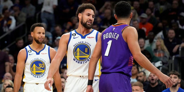 Golden State Warriors guard Klay Thompson, #11, and Phoenix Suns guard Devin Booker, #1, talk to each other during the second half of an NBA basketball game, Tuesday, Oct. 25, 2022, in Phoenix.