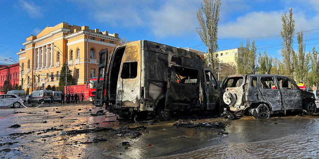 Cars sit damaged as underground pipes leak at the scene of a Russian attack on Kyiv, Ukraine on Monday, Oct. 10, 2022.