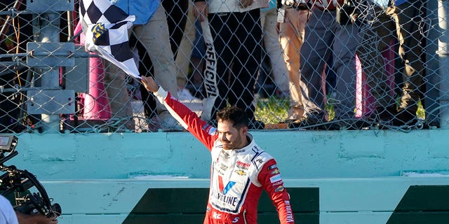 Kyle Larson waves the checkered flag after winning a NASCAR Cup Series auto race at Homestead-Miami Speedway, Sunday, Oct. 23, 2022, in Homestead, Florida. 
