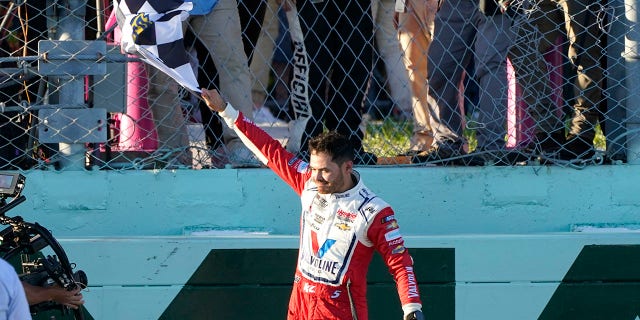 Kyle Larson waves the checkered flag after winning a NASCAR Cup Series auto race at Homestead-Miami Speedway, Sunday, Oct. 23, 2022, in Homestead, Florida.