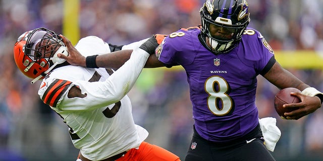 Ravens quarterback Lamar Jackson tries to fend off Cleveland Browns linebacker Deion Jones, Sunday, Oct. 23, 2022, in Baltimore.