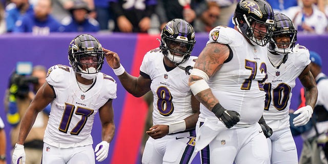 Baltimore Ravens' Lamar Jackson, #8, celebrates with Kenyan Drake, #17, and Ben Powers, #72, after Drake scored a touchdown during the first half of an NFL football game against the New York Giants, Sunday, Oct. 16, 2022, in East Rutherford, New Jersey. 