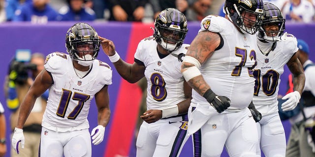 Baltimore Ravens' Lamar Jackson, #8, celebrates with Kenyan Drake, #17, and Ben Powers, #72, after Drake scored a touchdown during the first half of an NFL football game against the New York Giants, Sunday, Oct. 16, 2022, in East Rutherford, New Jersey.