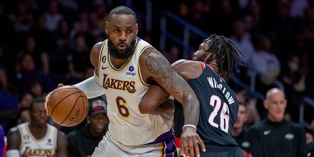 Los Angeles Lakers forward LeBron James, left, drives around Portland Trail Blazers forward Justise Winslow during the first half of an NBA basketball game Sunday, Oct. 23, 2022, in Los Angeles. 
