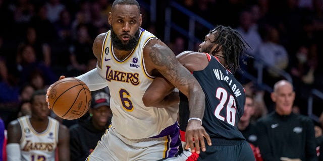 Los Angeles Lakers forward LeBron James, left, drives around Portland Trail Blazers forward Justise Winslow during the first half of an NBA basketball game Sunday, Oct. 23, 2022, in Los Angeles. 