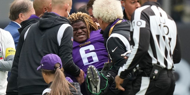 Minnesota Vikings safety Lewis Cine (6) grimaces as he receives treatment after an injury during an NFL match between Minnesota Vikings and New Orleans Saints at the Tottenham Hotspur stadium in London, Sunday, Oct. 2, 2022.