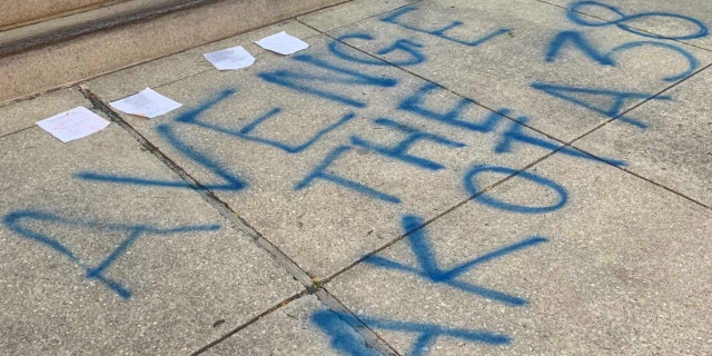 Graffiti at the base of the Lincoln statue in Chicago reads "Avenge the Dakota 38," referencing the 38 Dakota men whose execution Lincoln approved in 1862.