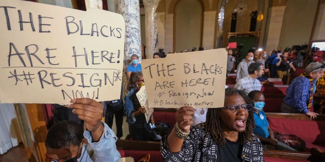 FILE - People hold signs and shout slogans before the starting the Los Angeles City Council meeting on Tuesday, Oct. 11, 2022 in Los Angeles. Cross-cultural coalitions have ruled Los Angeles politics for decades, helping elect both Black and Latino politicians to top leadership roles in the racially and ethnically diverse second largest city in America. But the year old recording of racist comments by the city's City Council president has laid bare the tensions over political power that have long quietly simmered between the Latino and Black communities. (AP Photo/Ringo H.W. Chiu, File)