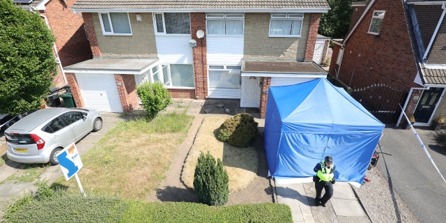 A police officer stands outside Lucy Letby's house on July 4, 2018.